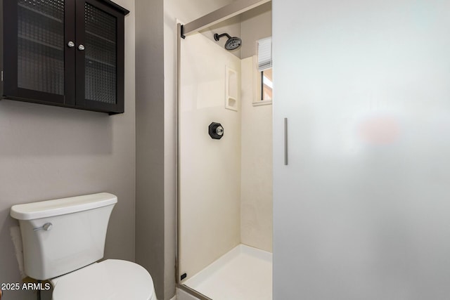 bathroom featuring a shower stall and toilet