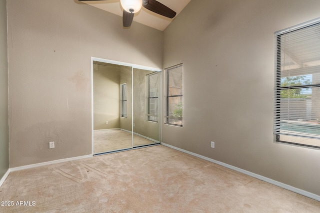 unfurnished bedroom with a closet, carpet flooring, multiple windows, and baseboards