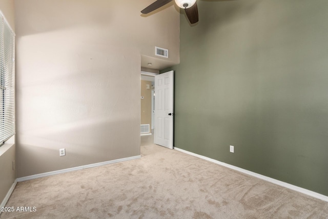 unfurnished room with visible vents, baseboards, a ceiling fan, and carpet floors