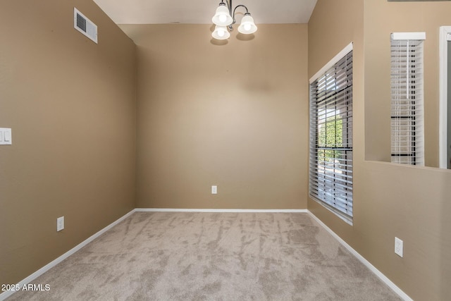 spare room with a notable chandelier, visible vents, baseboards, and carpet floors