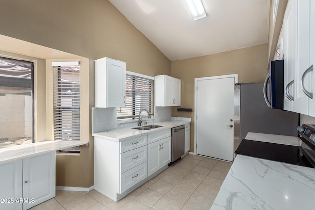 kitchen featuring a sink, light stone counters, appliances with stainless steel finishes, and white cabinets