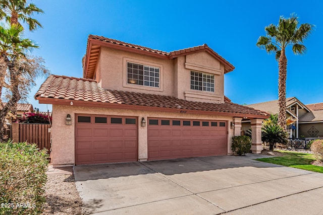 mediterranean / spanish-style home featuring an attached garage, fence, driveway, and stucco siding