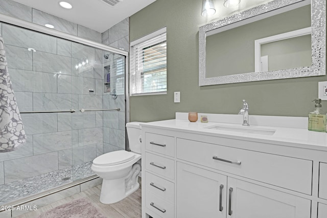 bathroom with recessed lighting, a shower stall, visible vents, toilet, and vanity