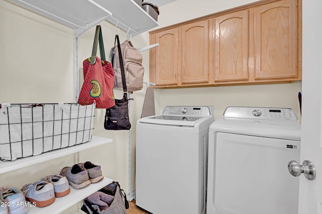 washroom with cabinet space and washer and clothes dryer