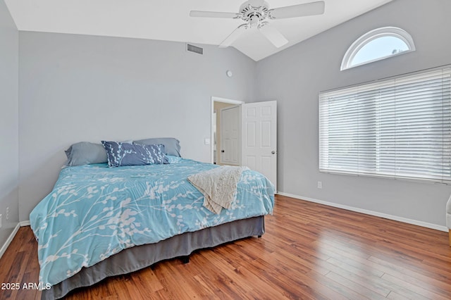 bedroom featuring baseboards, vaulted ceiling, visible vents, ceiling fan, and wood finished floors