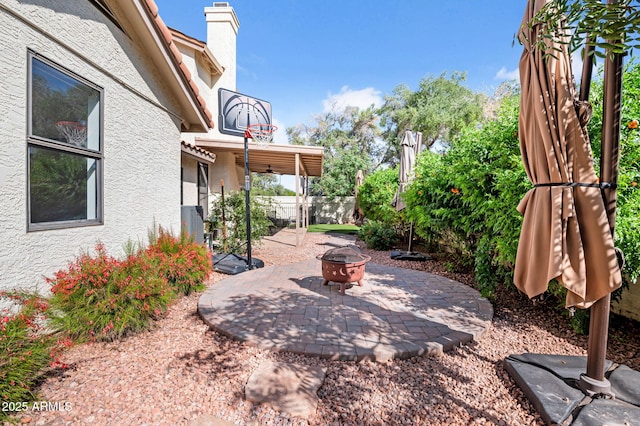 view of patio with an outdoor fire pit and fence