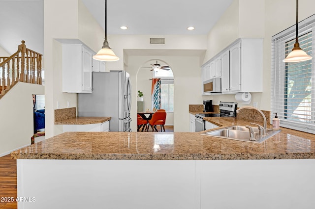 kitchen with visible vents, a sink, a ceiling fan, white cabinetry, and stainless steel appliances