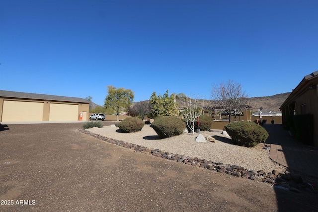 view of yard with a garage and a mountain view