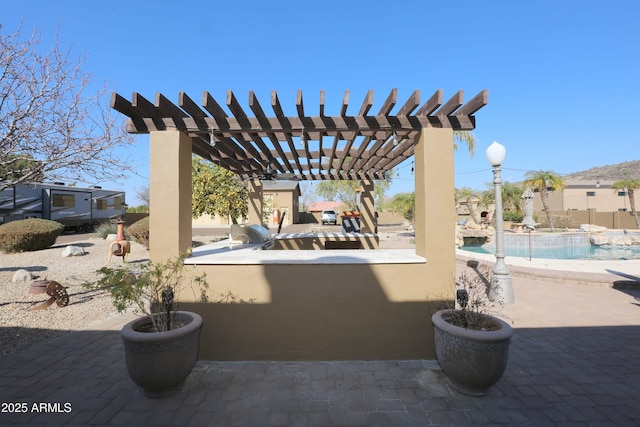 view of patio / terrace featuring a fenced in pool, a pergola, and exterior bar