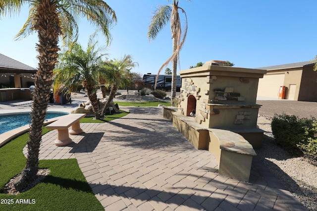 exterior space featuring a bar, a pool, a patio area, and exterior kitchen