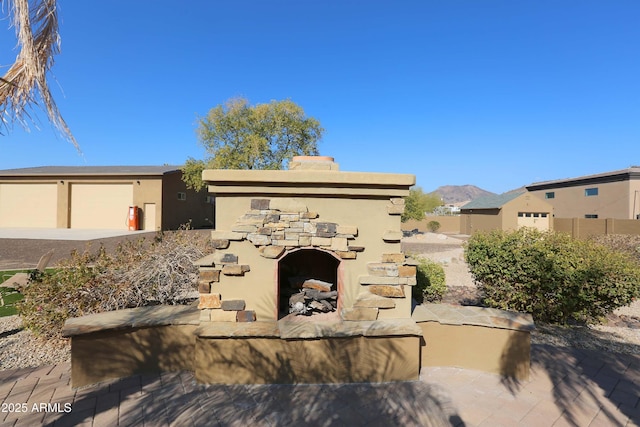 view of patio with exterior fireplace and a mountain view