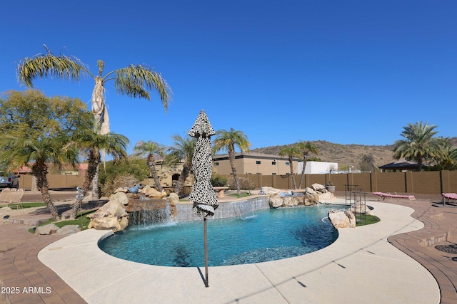 view of pool featuring a mountain view, a patio area, and pool water feature