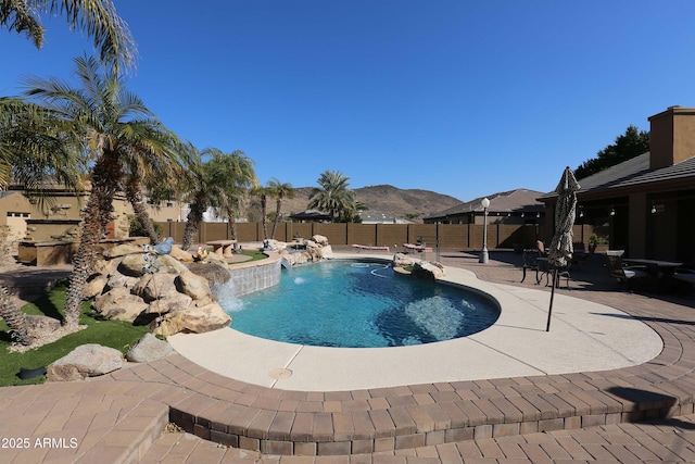 view of swimming pool featuring pool water feature, a mountain view, and a patio