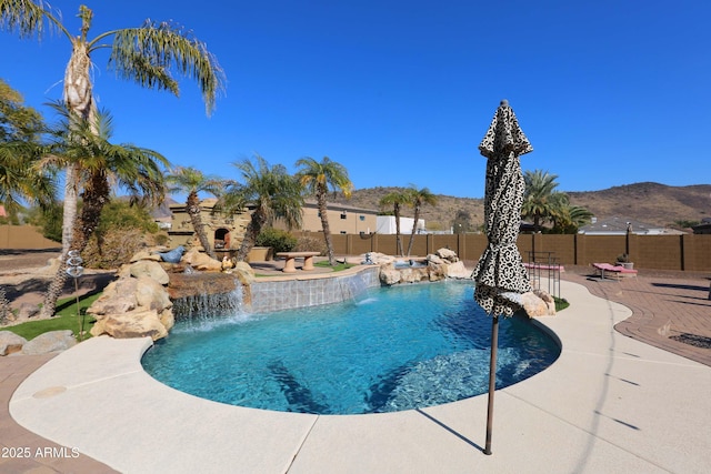 view of swimming pool with a mountain view, a patio area, and pool water feature