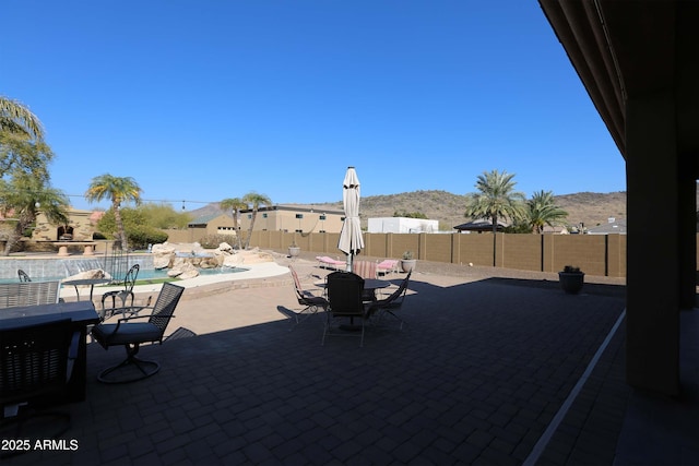 view of patio / terrace featuring a fenced in pool and a mountain view