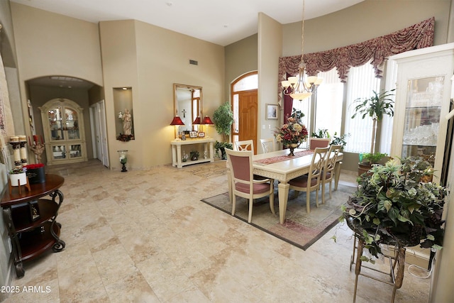 dining room featuring an inviting chandelier and a high ceiling