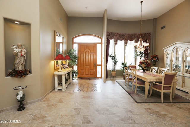 foyer featuring a towering ceiling and a notable chandelier