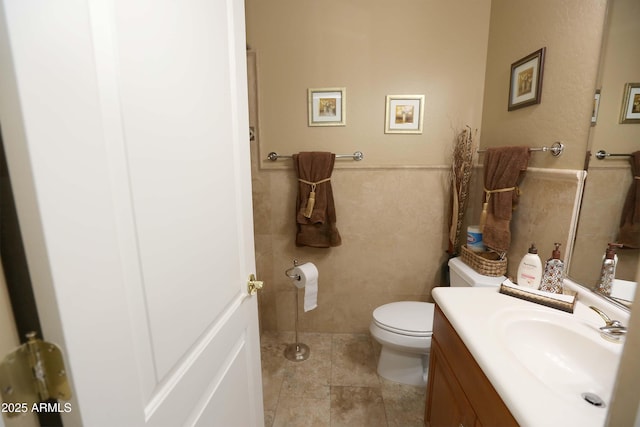 bathroom with vanity, tile walls, tile patterned floors, and toilet