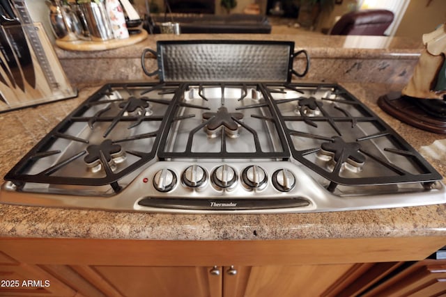 details featuring decorative backsplash and gas stovetop