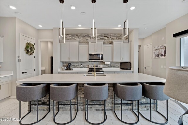 226 E Markwood Dr, Chandler, AZ 85286 - kitchen with appliances with stainless steel finishes, light countertops, a breakfast bar area, tasteful backsplash, and recessed lighting