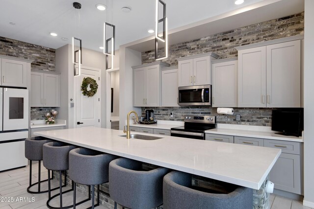 226 E Markwood Dr, Chandler, AZ 85286 - kitchen with stainless steel appliances, a sink, tasteful backsplash, a breakfast bar, and recessed lighting