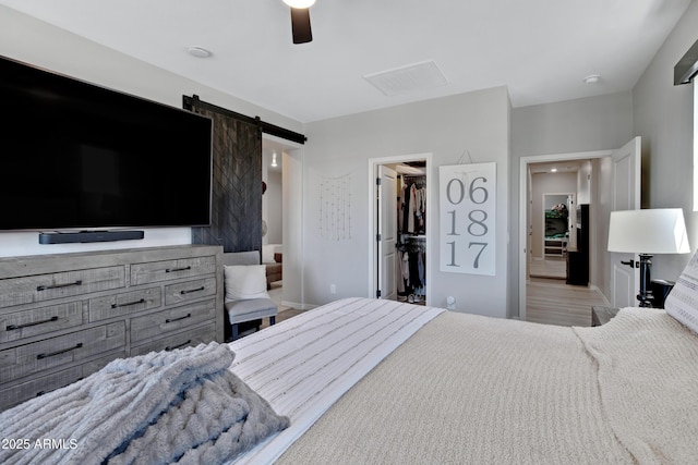 226 E Markwood Dr, Chandler, AZ 85286 - bedroom with a spacious closet, a barn door, a closet, ceiling fan, and baseboards