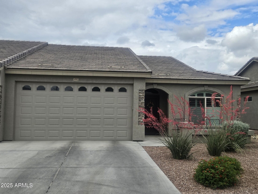 view of front of house featuring stucco siding, driveway, and a garage