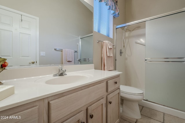 bathroom with toilet, vanity, tile patterned floors, and a shower with door