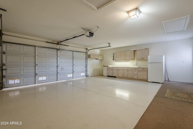 garage featuring white fridge and a garage door opener