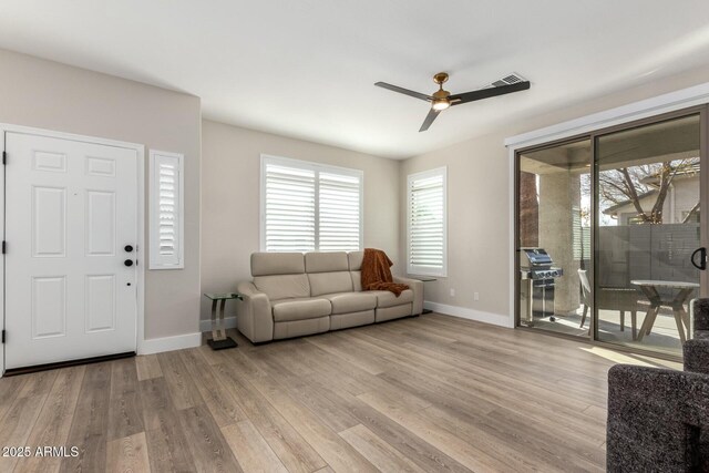 living room with light hardwood / wood-style floors and ceiling fan