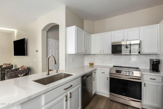 kitchen featuring sink, white cabinetry, backsplash, stainless steel appliances, and dark hardwood / wood-style flooring