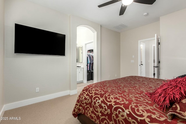 carpeted bedroom with a spacious closet, a closet, and ceiling fan