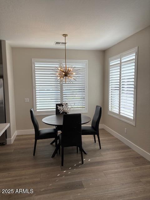 dining space featuring an inviting chandelier and dark hardwood / wood-style floors