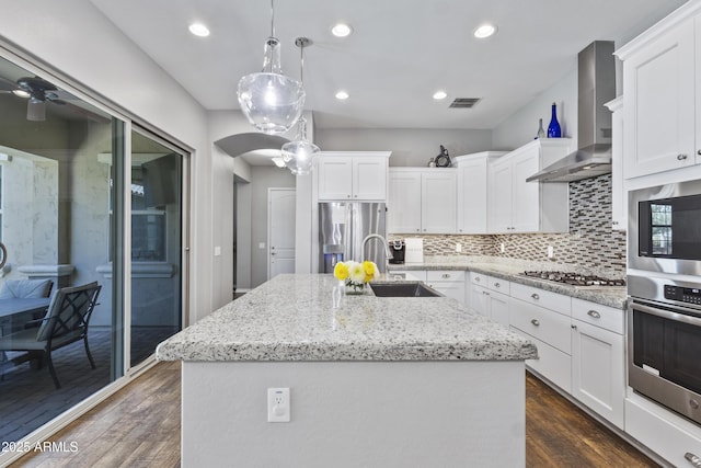 4302 E Cynthia St, Gilbert, AZ 85295 - kitchen featuring appliances with stainless steel finishes, wall chimney exhaust hood, an island with sink, dark wood-type flooring, and backsplash