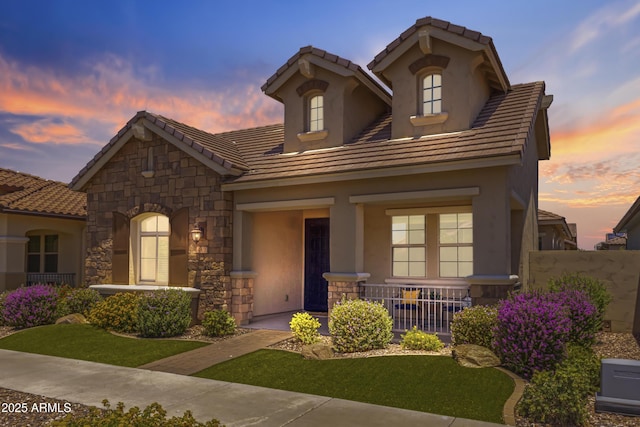 4302 E Cynthia St, Gilbert, AZ 85295 - view of front of property with a porch, stone siding, stucco siding, and a tile roof