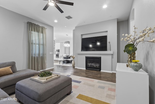 4302 E Cynthia St, Gilbert, AZ 85295 - living area featuring a ceiling fan, wood finished floors, recessed lighting, a glass covered fireplace, and a chandelier