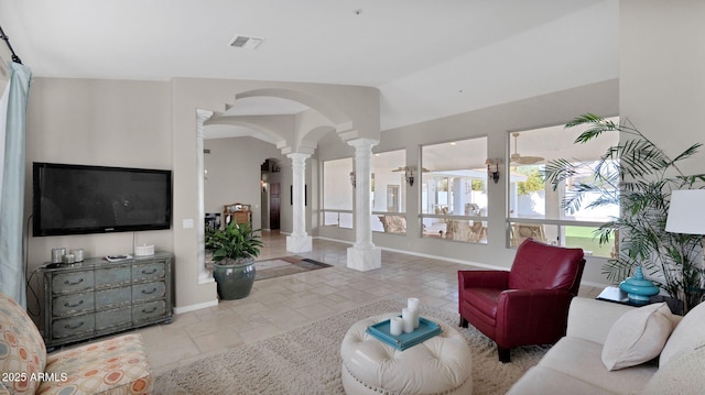 living room with ornate columns and vaulted ceiling