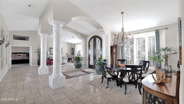 dining room featuring an inviting chandelier, lofted ceiling, decorative columns, and a wealth of natural light