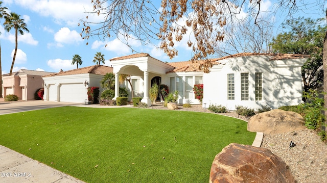 mediterranean / spanish-style home featuring a garage and a front yard