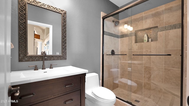 bathroom with walk in shower, vanity, and toilet