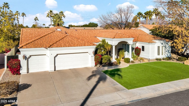 mediterranean / spanish house with a garage and a front yard