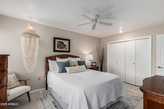 bedroom with light hardwood / wood-style floors, a closet, and ceiling fan