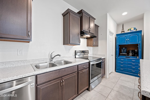 kitchen with appliances with stainless steel finishes, dark brown cabinets, light tile patterned flooring, and sink