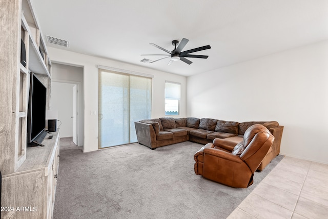 carpeted living room with ceiling fan