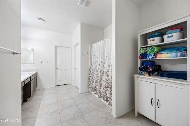 bathroom with tile patterned flooring, vanity, and curtained shower