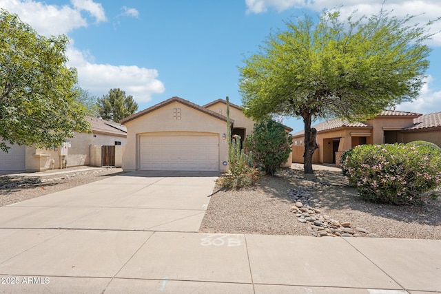 mediterranean / spanish home featuring a tiled roof, a garage, driveway, and stucco siding
