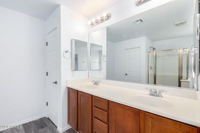 bathroom with a shower with door, vanity, and wood-type flooring