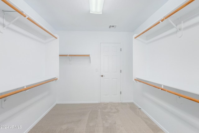 walk in closet featuring light carpet