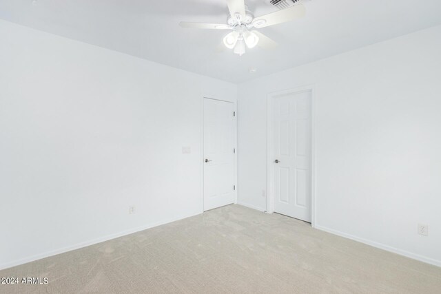 unfurnished room with light colored carpet and ceiling fan