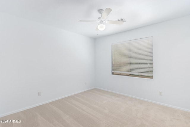 carpeted spare room with ceiling fan